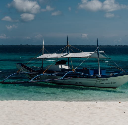 a boat on the beach with a boat in the water