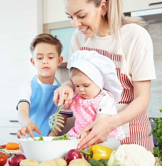 a woman and two children are cooking in a kitchen