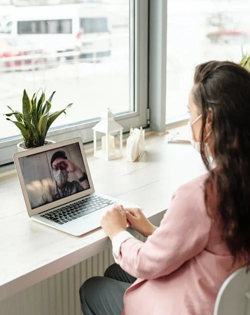 a woman sitting at a desk with a laptop computer