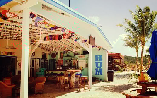 The open patio at Soggy Dollar, with tables and umbrellas