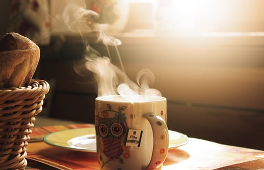 a cup of coffee and a basket of bread
