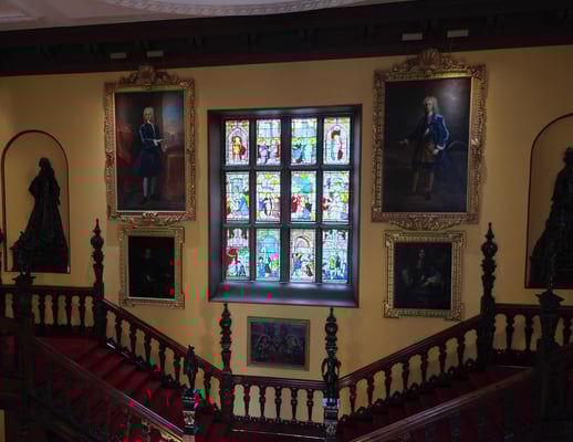 Staircases in a mansion with paintings and artifacts