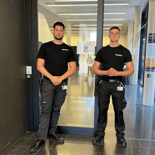 Zwei Sicherheitskräfte in "SECURITY"- Shirts