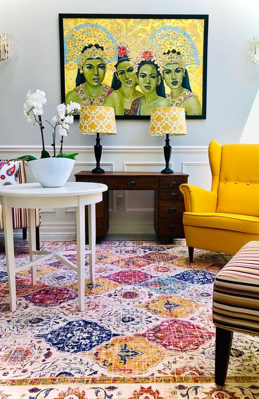 a living room with a yellow chair and a painting