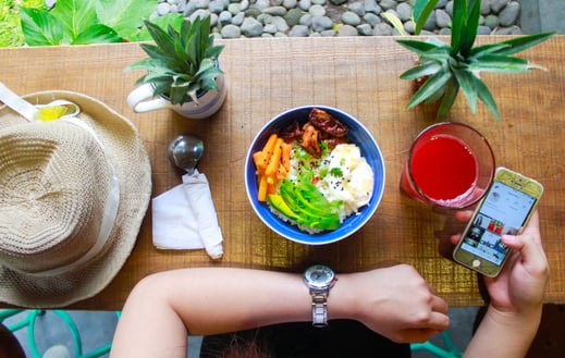 woman holding iphone while eating