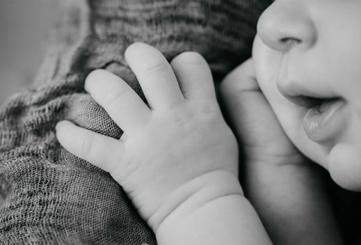 Détail en noir et blanc de la bouche et de la main d’un nouveau-né – photo naissance Gard