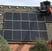 a man on a lift platform working on a solar paneled roof