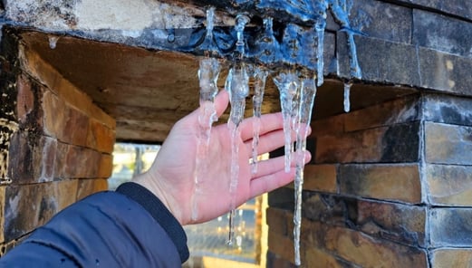 a person's hand holding a piece of ice