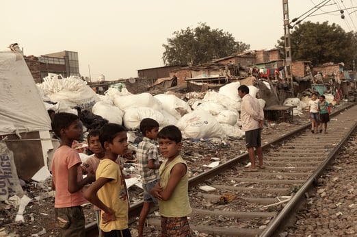 a group of children standing on a train track of Kirti Nagar