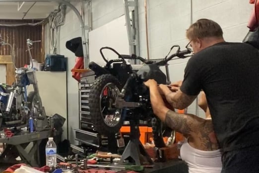 woman and man wrenching on a motorcycle