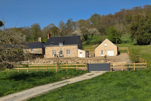 Clôture en bois installée autour d’une maison dans un paysage naturel du Sud-Manche