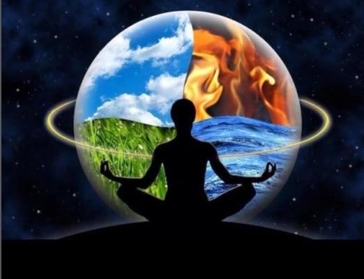 a person sitting in a lotus position in front of a picture of a planet