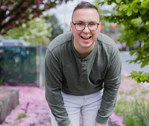 A happy autistic male adult, smiling at the camera