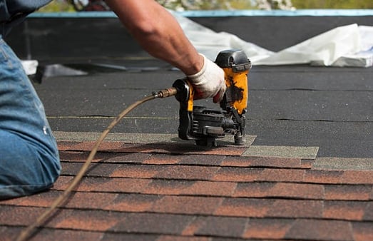 worker installing asphalt roof