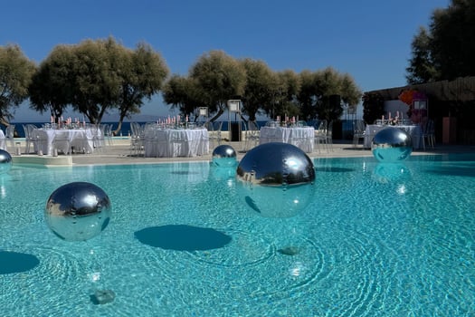 Mirror silver balls reflecting the scenic beauty of a Santorini wedding venue.