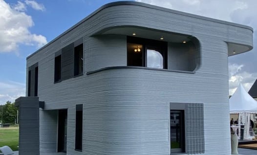 Impresora 3D construyendo una vivienda con tecnología avanzada y materiales innovadores.