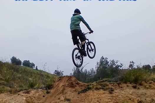 "Mountain biker stiff in the air with extended arms and legs