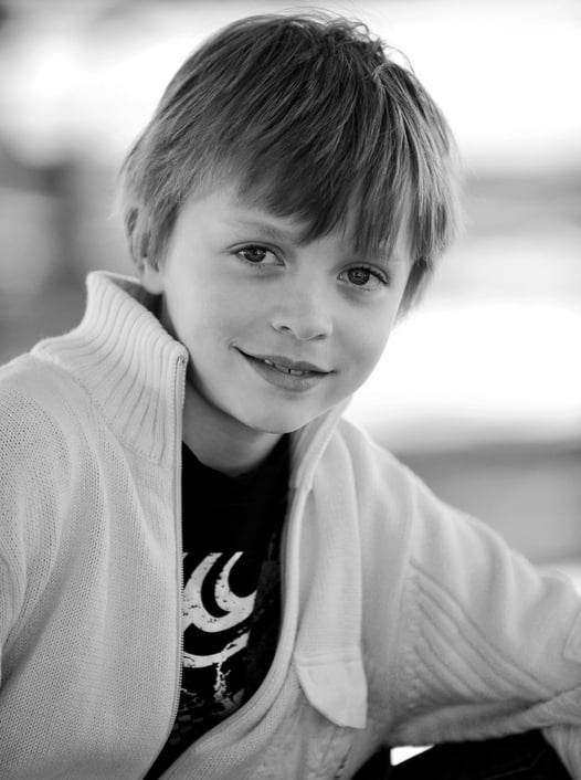 A young boy with a smile on his face photographed by Peter Pickering