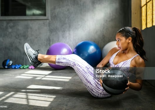 a woman doing a crunch ball exercise