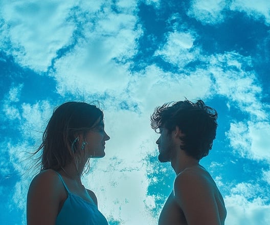 a man and woman standing in front of a blue sky