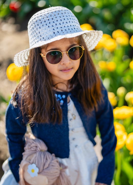 a little girl wearing a hat and sunglasses