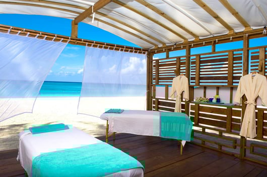 a couple of beds in a room with a view of the ocean from The Westin Grand Cayman hotel