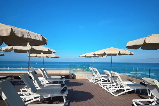 lounge chairs and umbrellas on a deck deck from H10 Costa Adeje Palace hotel
