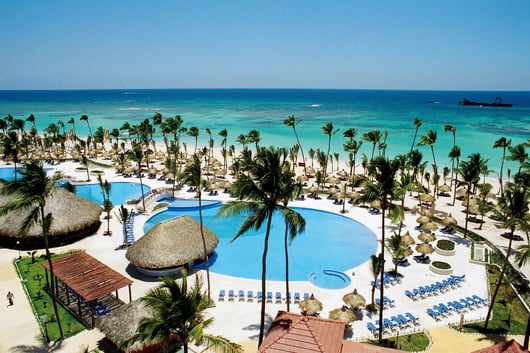 a resort pool with a view of the ocean from Bahia Principe Grand Punta Cana hotel