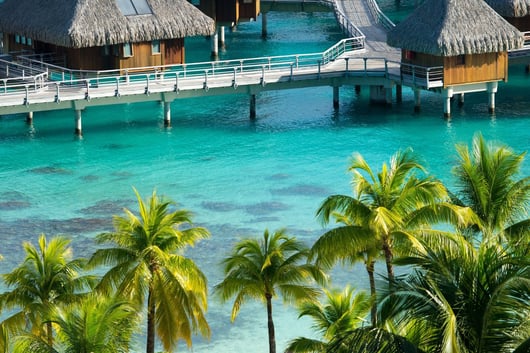 a beach resort with a pier and palm trees at Conrad Bora Bora Nui in Bora Bora