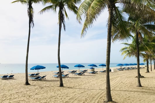 a beach with blue umbrellas and blue umbrellas, the Ritz Carlton, USA