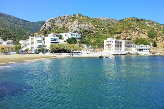 a beach with a mountain in the background Anthemis Hotel