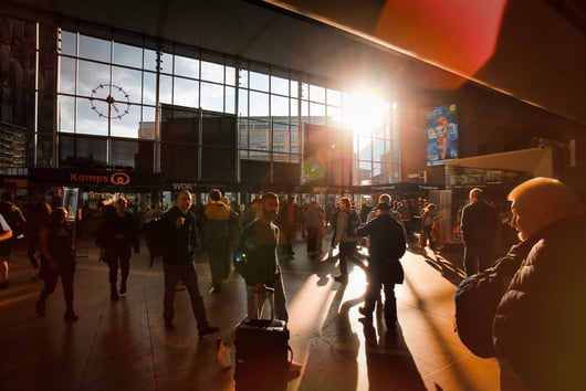 a group of people walking through a busy train station