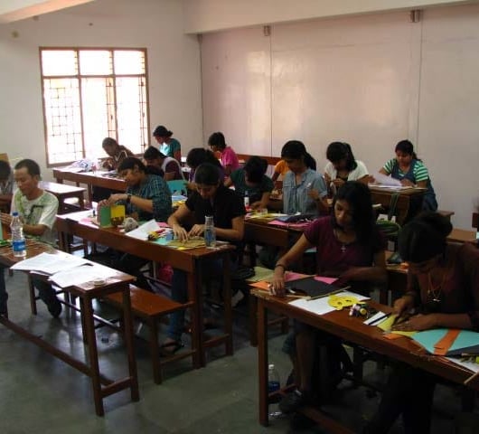A classroom of Montessori trainees making Montessori materials during a Montessori workshop.