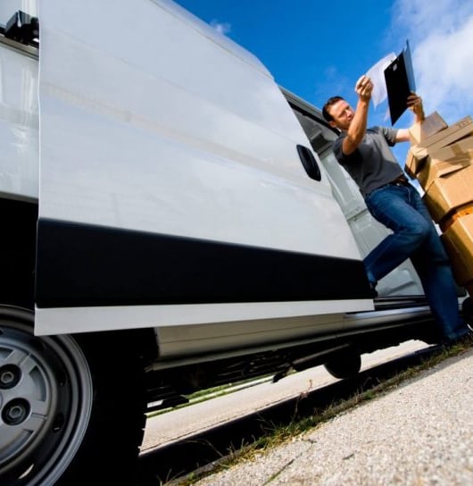 a man standing next to a van with boxes on it