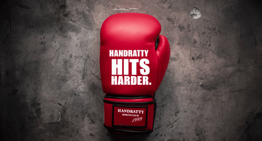 a red boxing glove with the words HANDRATTY hits harder