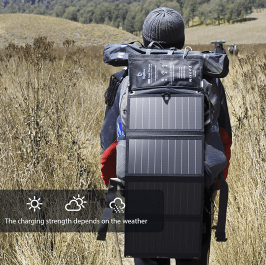 Backpacker using a BigBlue Solar Charger harnessing sunlight to power devices while hiking