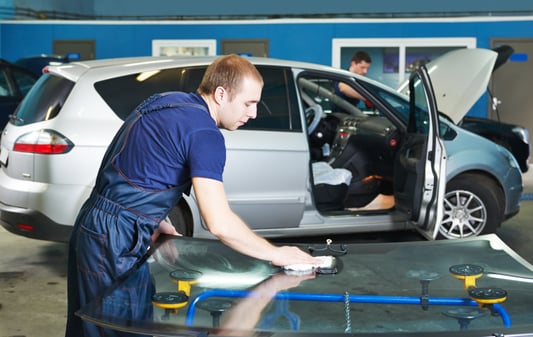 a man in a blue shirt is cleaning a car