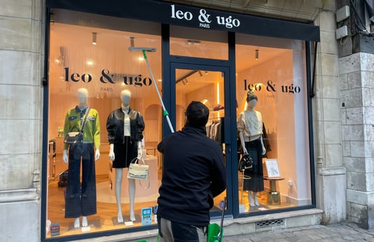 Un homme nettoyant une vitrine Léo et Ugo boutique de vétements à Rouen m&m services