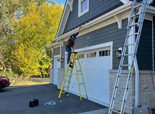 a man is standing on a ladder to reach bulbs in central Illinois