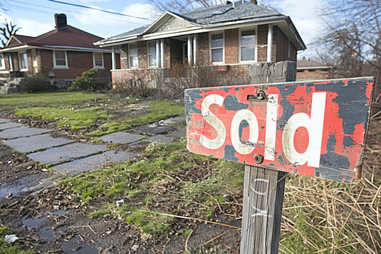 SOLD sign in front of a distressed home