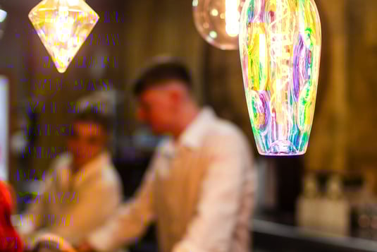 a man and woman standing in front of a bar