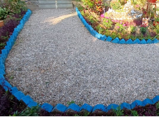 a garden with a gravel path and a gravel path