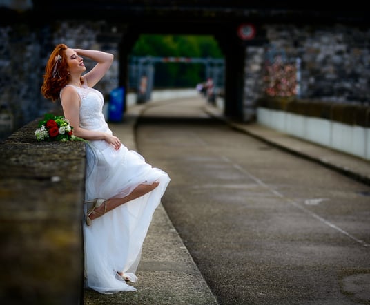 a woman in a white dress sitting on a ledge