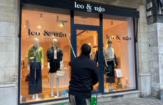 Un homme nettoyant une vitrine Léo et Ugo boutique de vétements à Rouen m&m services