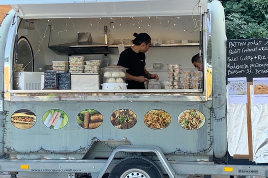 a man is standing in front of a food truck