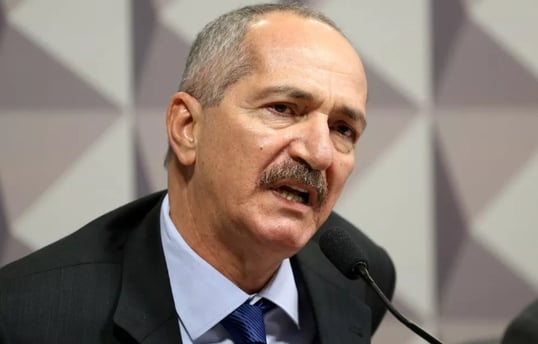 a man in a suit and tie is speaking into a microphone