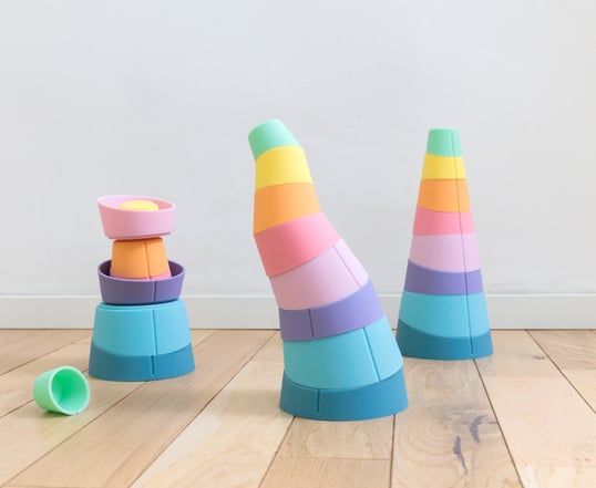 Three curved structures made of colorful stacking rings