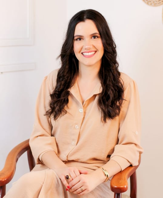 a woman in a tan dress sitting in a chair