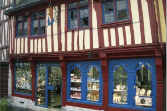 a store front of a building with a clock on the outside