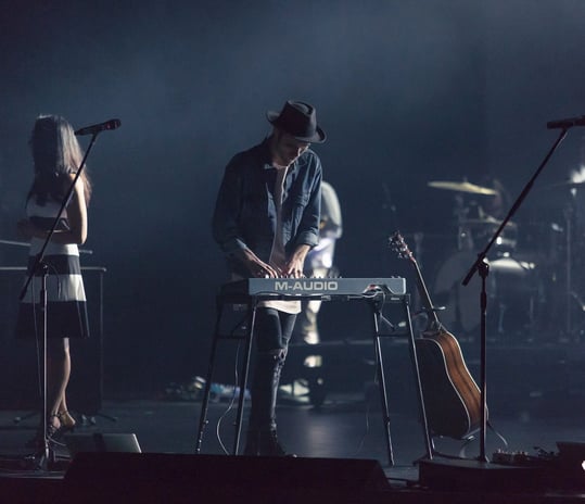 a man playing a keyboard on stage with a keyboard